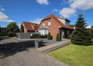 a brick house with a tree in the front yard at Rote-Muehle in Greetsiel