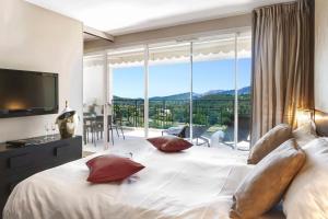 a bedroom with a large bed with a large window at Royal Mougins Golf, Hotel & Spa de Luxe in Mougins