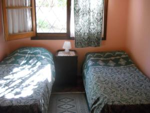 a room with two twin beds and a window at Los Aguaribays in Los Cocos