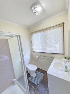 a bathroom with a toilet and a sink and a window at Holiday Home in Drouin in Drouin +41 photos