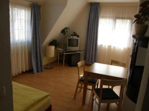 ein Wohnzimmer mit einem Tisch und ein Esszimmer in der Unterkunft Hotel Pension zu Dresden Altpieschen in Dresden