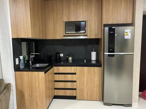 a kitchen with a stainless steel refrigerator and a microwave at Equipetrol Edificio Tuareg 110 in Santa Cruz de la Sierra