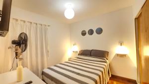 a bedroom with a bed and two lights and a fan at Departamento PB, patio y asador privados - NUEVO SERVICIO Estacionamiento 24hs INCLUIDO - Cerca de hotel Quinto Centenario, Nuevocentro shopping, Hospital Clinicas y Club Universitario Córdoba Sede central in Cordoba