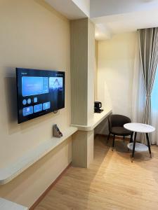 a room with a flat screen tv on a wall at Kawi Jaya Hotel in Nagoya