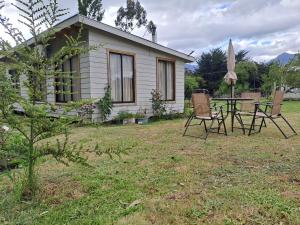 PueloCabañas camelia的一间有桌子、椅子和遮阳伞的房子