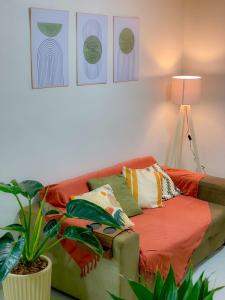 a living room with a couch with pillows and a plant at The Garden 103 - paz e sofisticação - 2 quartos ar condicionado in Cascavel