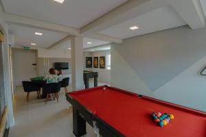 a living room with a pool table and a woman at Apartamento Familiar III Próximo Beto Carrero e Praia in Penha