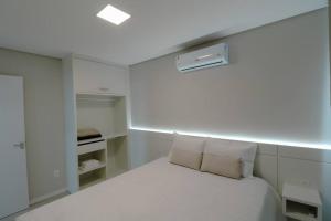 a white bedroom with a white bed with pillows at Apartamento Familiar III Próximo Beto Carrero e Praia in Penha +12 photos