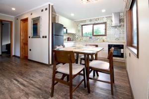 Una cocina con mesa y sillas y un refrigerador. en Mirabosque aparment Ejecutivos 6, en Osorno 23 fotos más