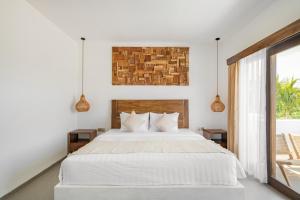 a bedroom with a white bed and a window at Baliterraneo Boutique Resort in Seminyak