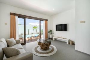 a living room with a couch and a table at Baliterraneo Boutique Resort in Seminyak