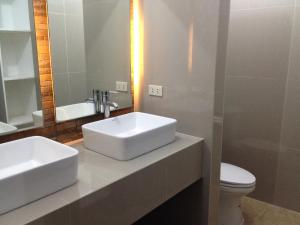 a bathroom with two sinks and a toilet and a mirror at Zacona Eco-Resort & Biblical Garden in Santa Monica
