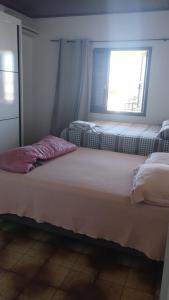 Dos camas en una habitación con ventana. en Pousada Habitación Aurora 2, en São Gabriel
