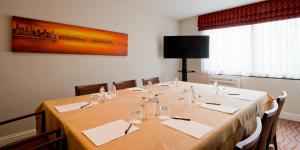 a conference room with a long table with chairs and a painting at Gresham Belson Hotel Brussels in Brussels