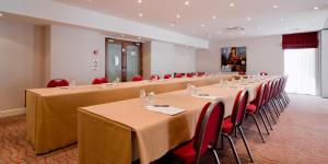 a meeting room with long tables and red chairs at Gresham Belson Hotel Brussels in Brussels
