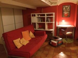 a living room with a red couch and a desk at Alba Chiara Holiday Home in Matera