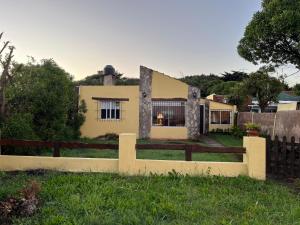 a yellow house with a fence in front of it at el maiten in Mar del Plata
