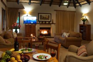 a living room with a table and a fireplace at Kruger Park Lodge Unit No. 243 in Hazyview