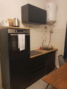 eine Küche mit schwarzem Backofen und Spüle in der Unterkunft Monteurwohnung Heilbronn Zentrum in Heilbronn