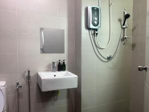 a bathroom with a sink and a shower with a mirror at d'Tempat Country Club, Hijayu 3d, Terrace House in Siliau +22 photos
