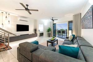a living room with a couch and a flat screen tv at Sunset Penthouse - Unique Panoramic Rooftop Retreat in Larrakeyah