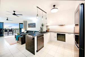 an open kitchen and living room with a couch at Sunset Penthouse - Unique Panoramic Rooftop Retreat in Larrakeyah
