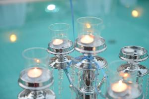 a group of glass candle holders with candles at Hotel Sarajet e Pashait 1 in Dhërmi