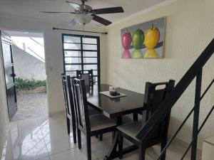 a dining room with a table and a painting of fruit at Merliot, Sta Tecla Frente Cto Comer La Plaza Merliot in Nueva San Salvador