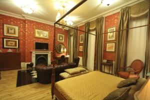 a bedroom with a bed and a couch and a fireplace at Opulence Boutique Hotel in London