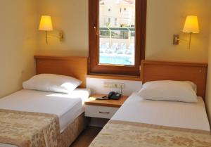 Postel nebo postele na pokoji v ubytování Aes Club Hotel