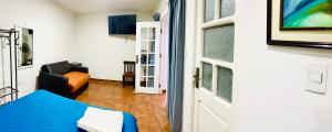 a room with a blue bed and a chair and a door at Casa céntrica Las Higueras in Tarija