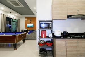 a kitchen with a pool table and a living room at บลูสกาย พูลวิลล่า ชะอำ หัวหิน Blue Sky Pool Villa in Ban Bo Fai (1)