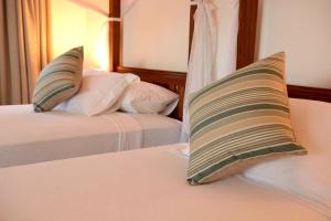 a hotel room with two beds and two pillows at Kisiwa on the Beach in Paje