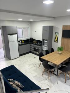 a kitchen with a wooden table and a dining room at Recanto Brisa e Mar in Palhoça