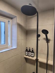 a shower in a bathroom with three bottles on a shelf at Hwagok August in Seoul