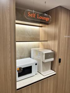 a kitchen with a microwave and a self lounge sign at Hwagok August in Seoul +16 photos