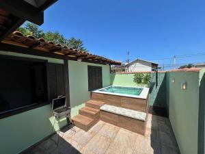 Casa aconchegante a 7 min da Praia في بوزيوس: حديقة خلفية مع حمام سباحة ومنزل