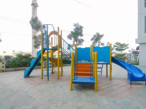 a playground with a blue and yellow slide at Minimalist and Comfy Studio at Grand Dhika City Apartment By Travelio in Bekasi