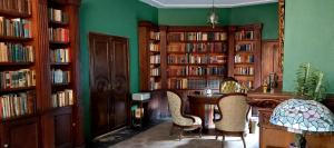 biblioteca con librerie in legno, tavolo e sedie di Residencia Casa del Roble 1 a Cuernavaca