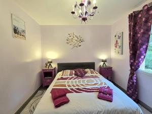 ein Schlafzimmer mit einem Bett und einem Kronleuchter in der Unterkunft Belle maison plain-pied à 2 pas de Périgueux, terrasse, jardin clos, confort moderne, animaux bienvenus - FR-1-616-99 in Champcevinel