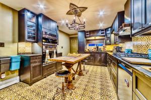 a large kitchen with wooden cabinets and a wooden table at Neocolonial Nouveau Kensington Vacation Home in Vancouver