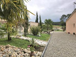 einen Garten mit Felsen und Palmen und einen Gehweg in der Unterkunft Belle maison plain-pied à 2 pas de Périgueux, terrasse, jardin clos, confort moderne, animaux bienvenus - FR-1-616-99 in Champcevinel