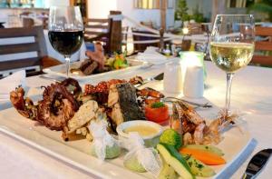 a table with two plates of food and glasses of wine at Kisiwa on the Beach in Paje