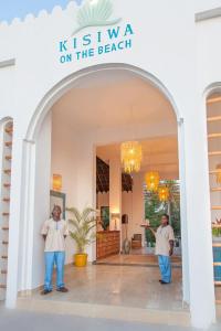 two men standing under an archway in a building at Kisiwa on the Beach in Paje