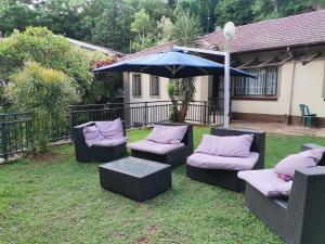 a group of chairs and an umbrella in a yard at Bombay Crush in Durban