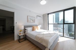 Un dormitorio blanco con una cama grande y una ventana grande. en Lux 39th floor 2br 2bath, River view, Pool, Gym, Wifi, en Brisbane