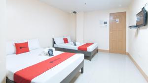 una stanza con due letti e una televisione di RedDoorz at Isabelita Hotel Tuguegarao City a Tuguegarao