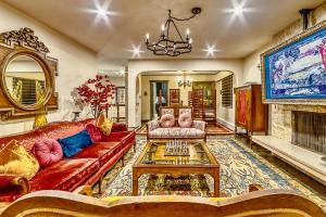 a living room with a red couch and a fireplace at Neocolonial Nouveau Kensington Vacation Home in Vancouver