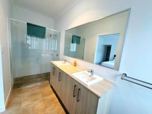 ein Badezimmer mit Waschbecken und großem Spiegel in der Unterkunft Brand New Fantastic Luxury 4 bedroom Home in Park Ridge + 15 Fotos