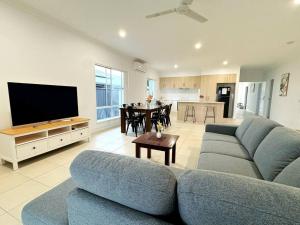 ein Wohnzimmer mit einer blauen Couch und einem Fernseher in der Unterkunft Brand New Fantastic Luxury 4 bedroom Home in Park Ridge